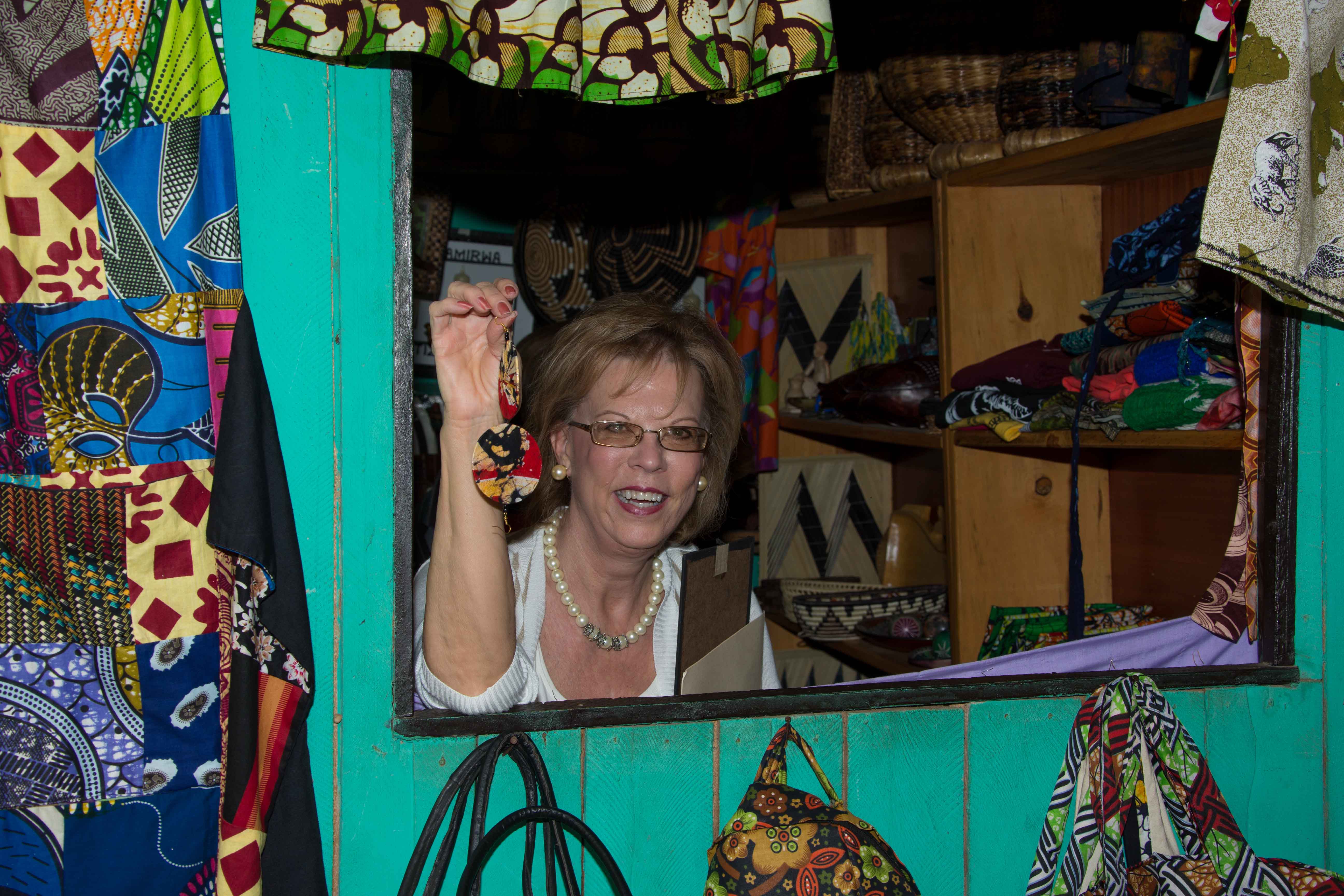 Dr. Terry Neese shopping at PEACE THROUGH BUSINESS(r) graduate, Elise Rida Musomandara's Oela Company, LTD; a handicraft boutique.